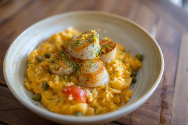 Scallop risotto dish in restaurant