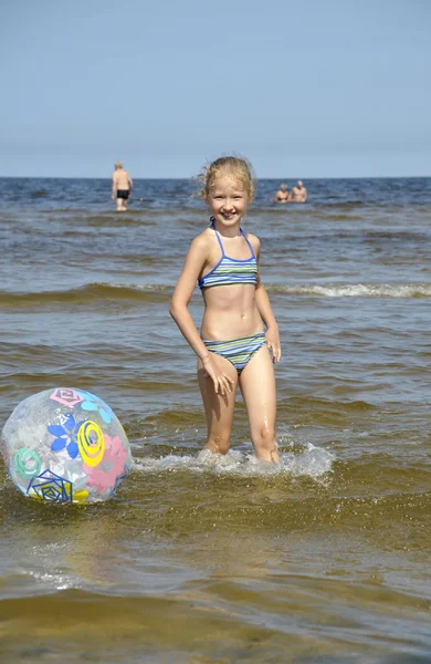 Het meisje speelt met een bal op Zeekust in jurmala (Letland). — Stockfoto