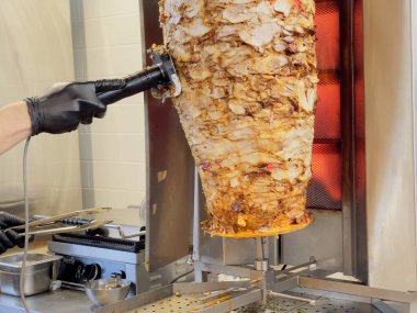 Isıtılmış bir işyerinden et kesmek shawarma yapmak için kesici bir aletle