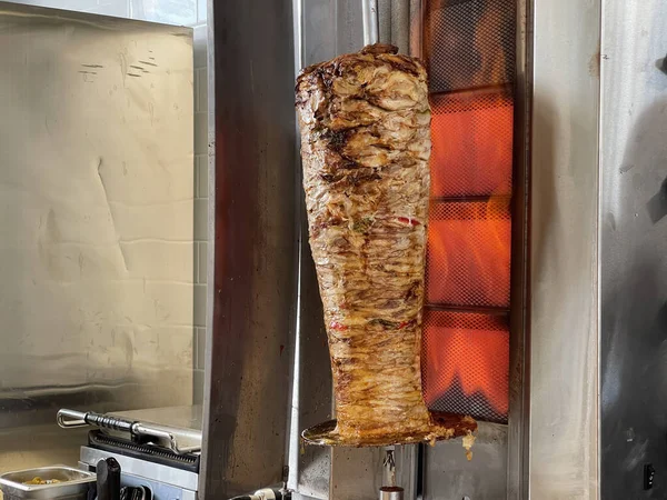 Orta boy bir ateşte dönen bir tükürüğü ısıtmak ve shawarma için et pişirmek (donör, giros, doner kebap).