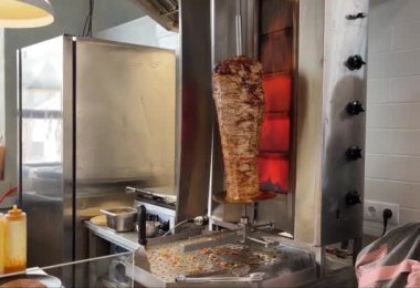 Orta boy bir ateşte dönen bir tükürüğü ısıtmak ve shawarma için et pişirmek (donör, giros, doner kebap).
