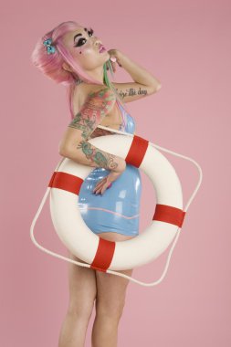 genç kadın üzerinde pembe bir arka plan ile float tüp poz