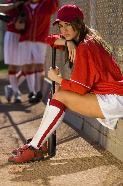 Joueur de baseball assis avec une chauve-souris — Photo