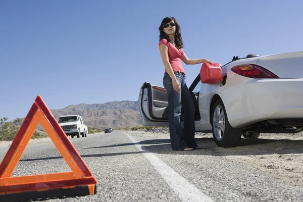 Mujer joven repostando su coche — Foto de Stock