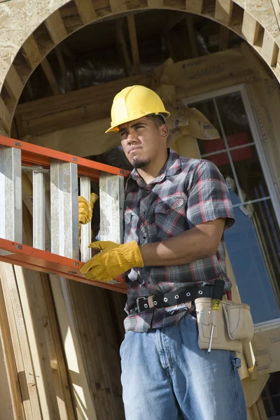 Worker carrying stepladder — Stock Photo, Image