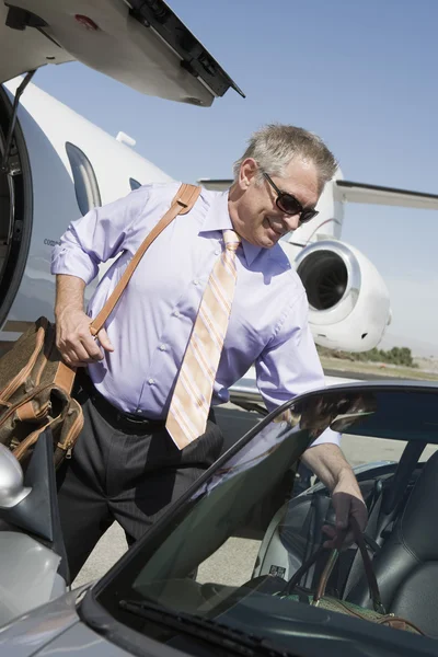 Senior-Geschäftsmann hält Gepäck im Auto — Stockfoto