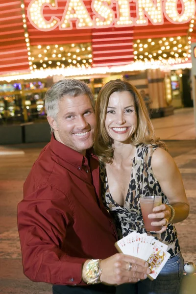Couple With Playing Cards And Drink Standing Against Casino — Stock Photo, Image