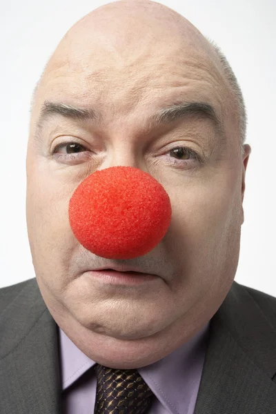 Ledsen affärsman bära clown näsa — Stockfoto