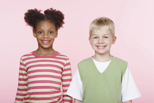 ピンクの背景に対して多民族の子供たち — ストック写真