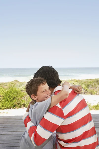 Pai e filho abraçando no molhe — Fotografia de Stock