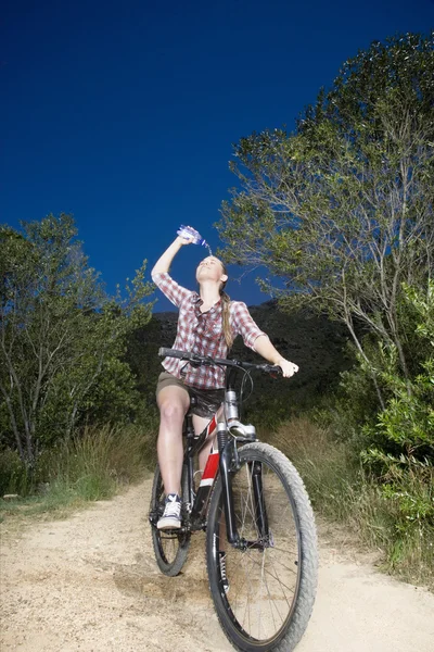 Mujer motociclista derramando agua sobre la cara — Foto de Stock