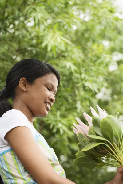 Menina olhando para flores frescas — Fotografia de Stock