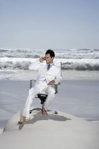 Uomo d'affari che utilizza il telefono cellulare sulla spiaggia — Foto Stock