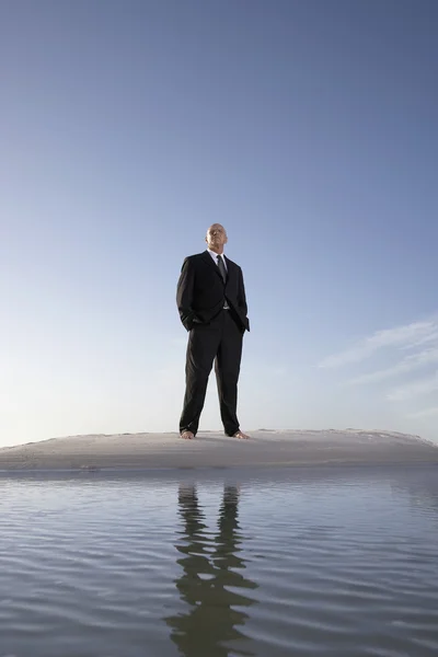 Бизнесмен стоит на пляже — стоковое фото