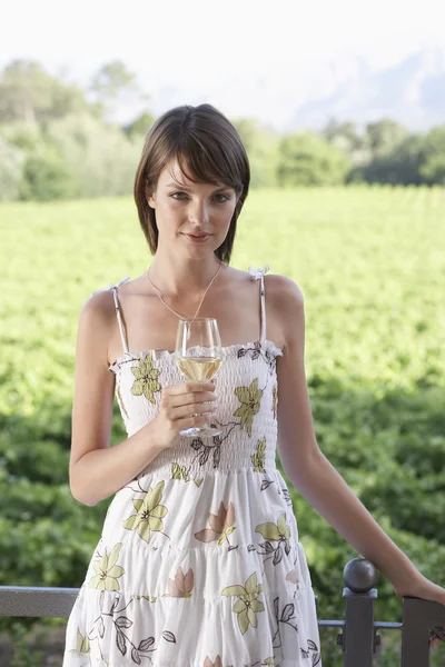 Mujer con una copa de vino en el campo — Foto de Stock