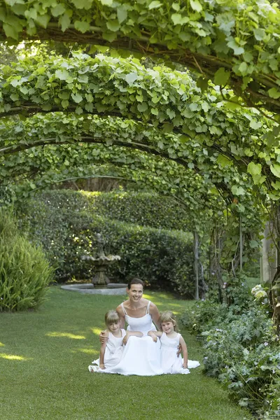 Girls And Bride Squatting Under Ivy Arches — Stock Photo, Image