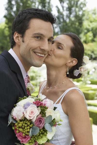 Bruden kysser glad brudgummen — Stockfoto