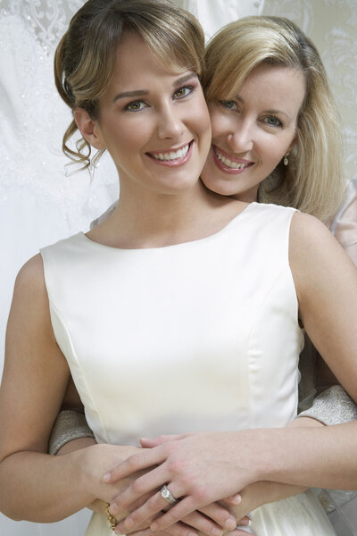 Счастливая мать обнимает невесту
