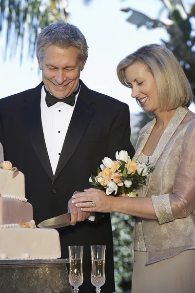 Paar schneidet Hochzeitstorte an — Stockfoto