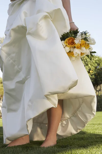 Bruid in jurk bedrijf rozen — Stockfoto