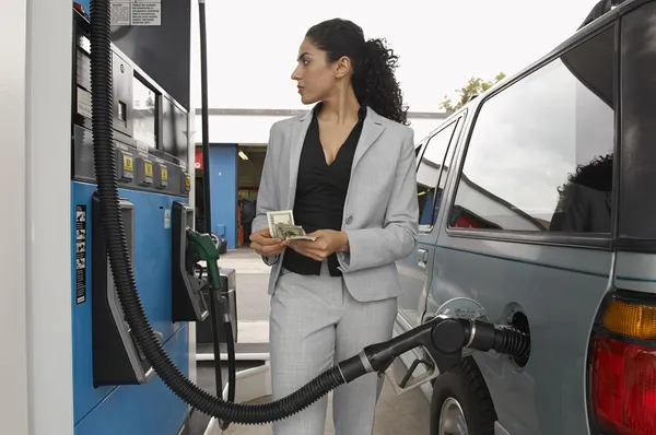 Žena tankování aut u benzinové pumpy — Stock fotografie