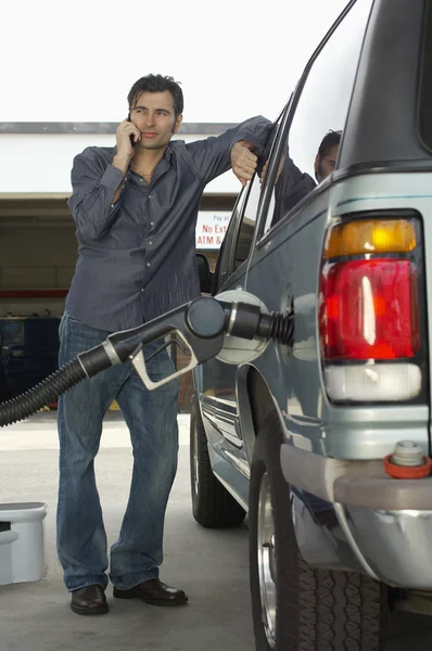 Hombre bombeando gas en el coche — Foto de Stock