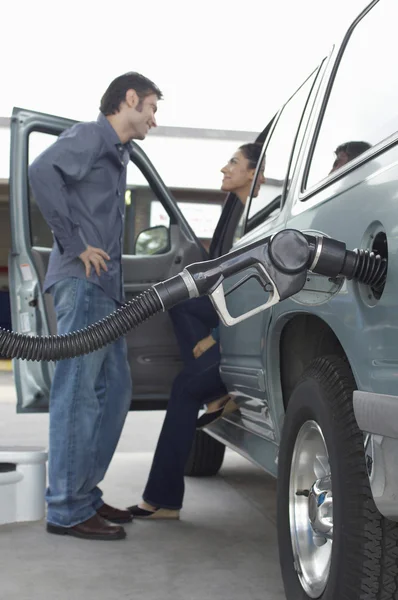 Pareja bombeo de gas en el coche —  Fotos de Stock