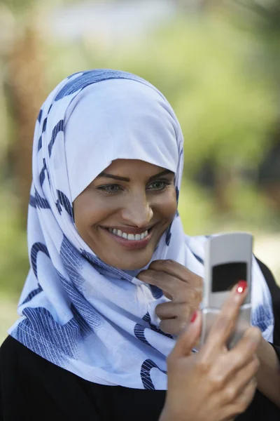 Mujer musulmana usando teléfono celular — Foto de Stock