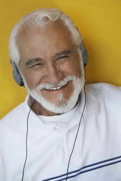 Homem sênior feliz ouvindo música através de fones de ouvido — Fotografia de Stock