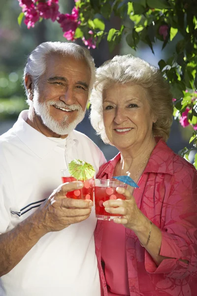 Pareja mayor feliz sosteniendo bebidas al aire libre — Foto de Stock