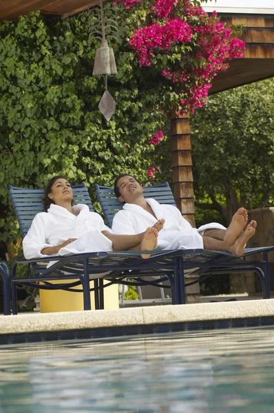 Paar in Bademänteln entspannt am Pool — Stockfoto