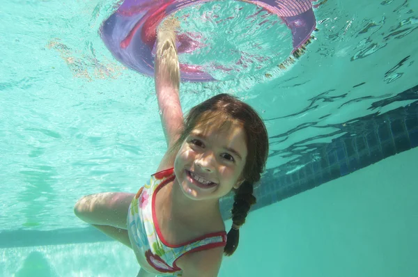 Ragazza che nuota sott'acqua con anello gonfiabile — Foto Stock