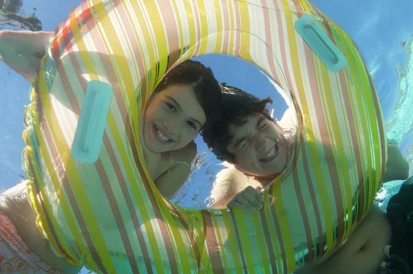 Feliz hermano y hermana mirando a través del anillo inflable —  Fotos de Stock