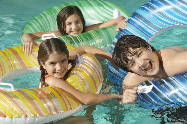 Broers en zussen genieten van samen in zwembad — Stockfoto