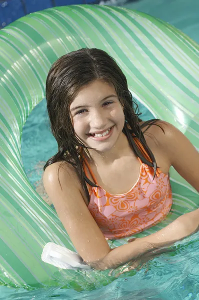 Девушка, плавающая в надувном кольце — стоковое фото