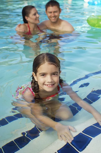 Söt flicka med föräldrar i pool — Stockfoto