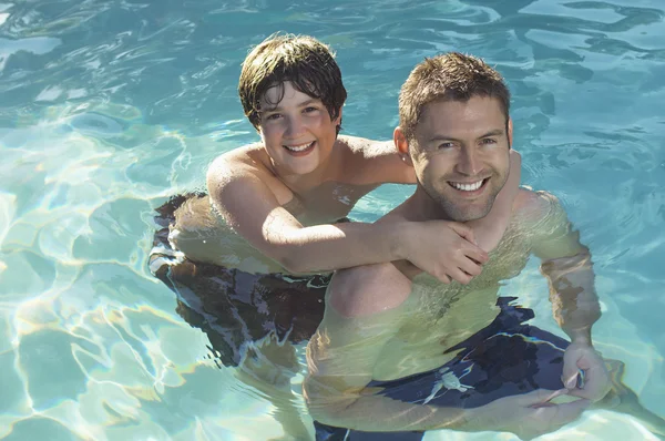 Отец и сын наслаждаются в бассейне — стоковое фото