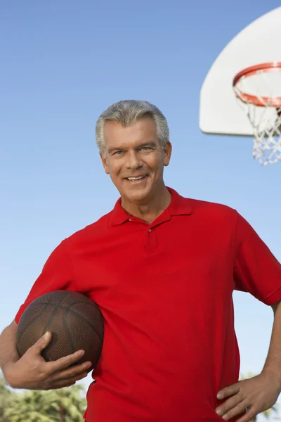 Homem segurando basquete na corte — Fotografia de Stock