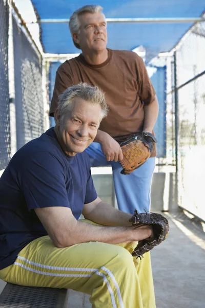 野球ダッグアウトでミトンを持つ男性 — ストック写真