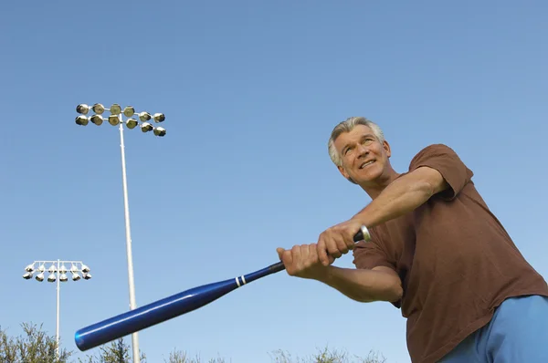 Man swingende honkbalknuppel buitenshuis — Stockfoto