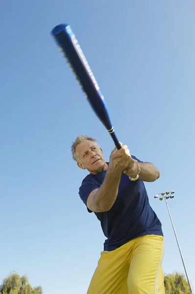 Homem sênior balançando bastão de beisebol — Fotografia de Stock