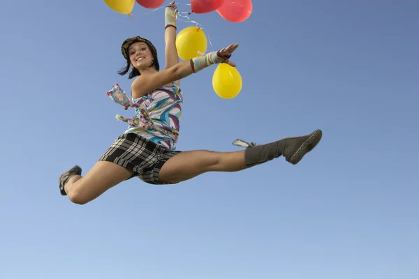 Mujer haciendo divisiones en aire sosteniendo globos — Foto de Stock