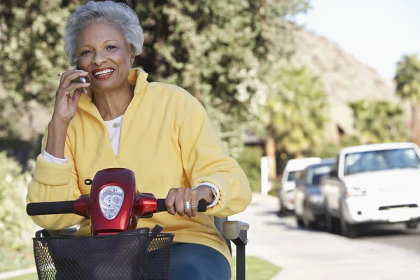 Femme utilisant un téléphone portable sur scooter moteur — Photo