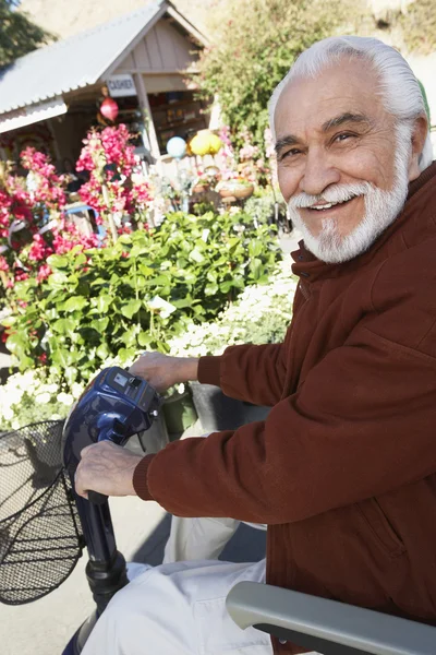 Üst düzey adam botanical Garden motorlu scooter üzerinde — Stok fotoğraf