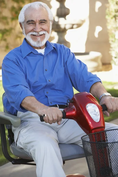 Senior man op motor scooter — Stockfoto