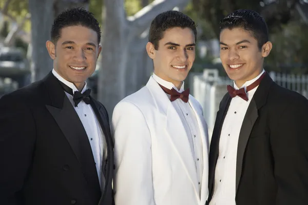 Tres jóvenes con esmoquin de pie juntos en Quinceañera — Foto de Stock