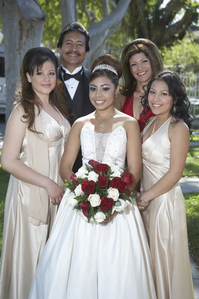 Quinceanera staande met ouders en vrienden in gazon — Stockfoto