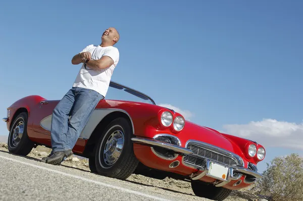 Hombre feliz de pie al lado de coche clásico en el camino — Foto de Stock