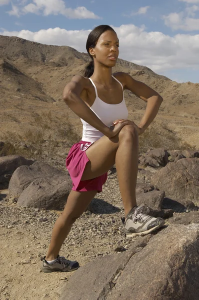 Feminino jogger alongamento no rock — Fotografia de Stock