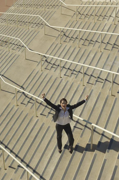 Empresaria con los brazos levantados en las escaleras — Foto de Stock